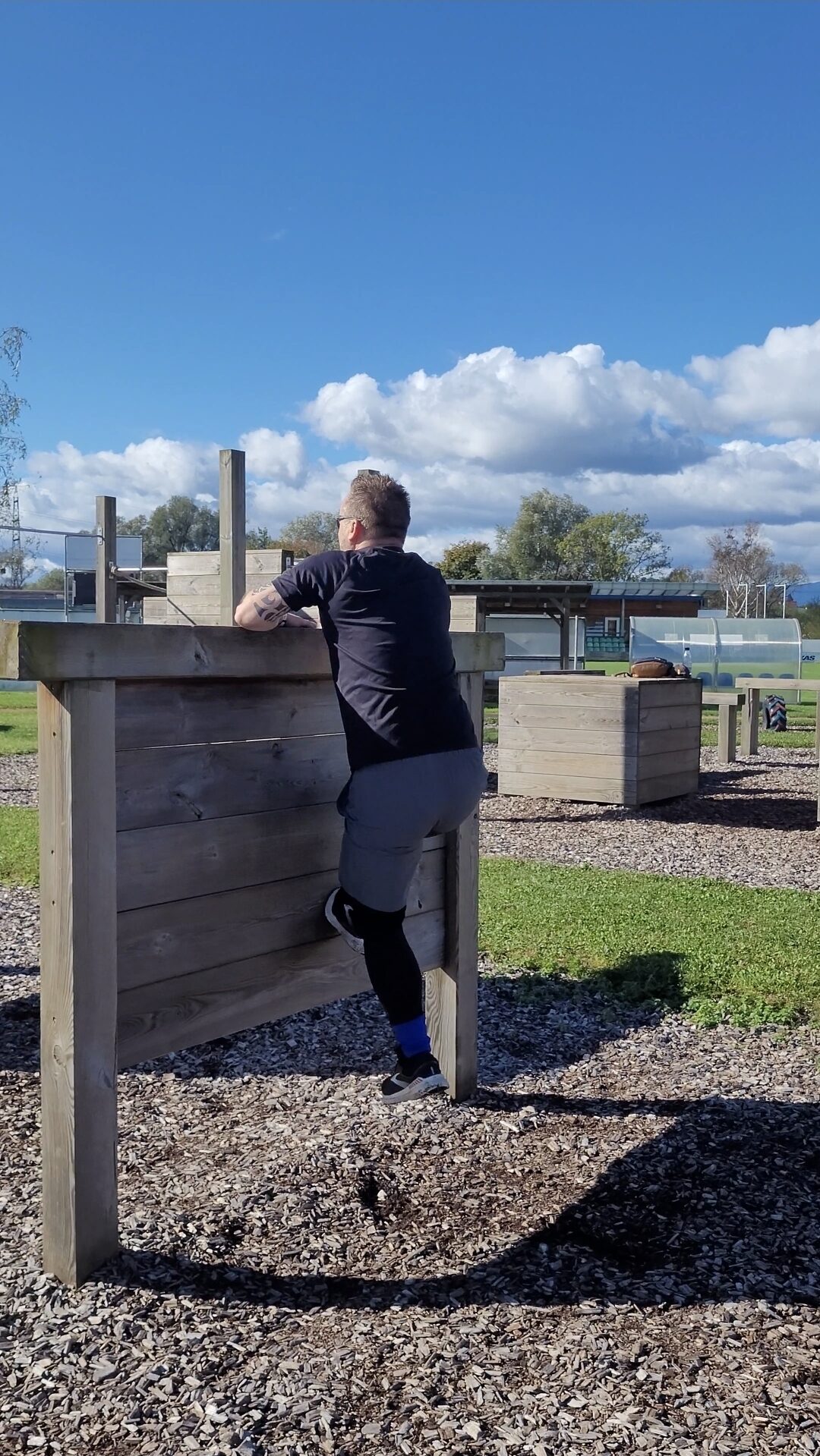 Teilnehmer überwindet eine Holzwand beim OCR-Training